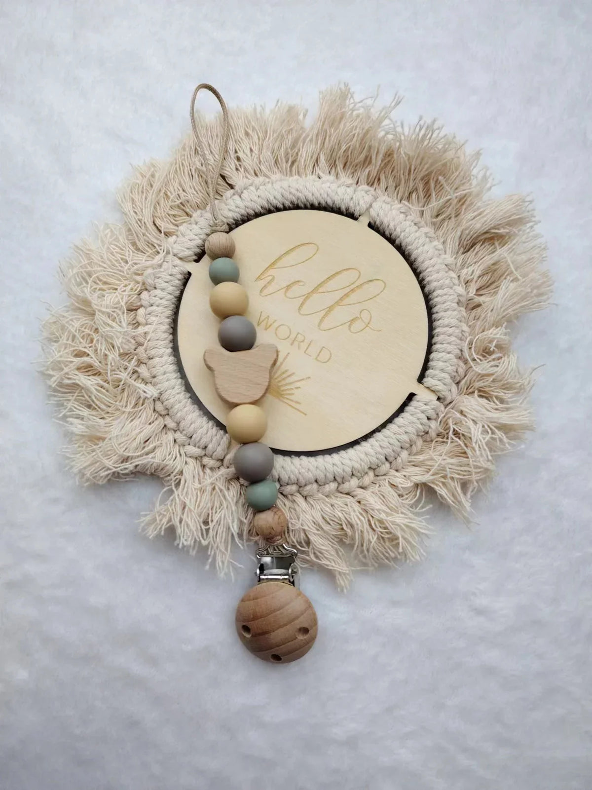 A personalized wooden baby pacifier clip featuring silicone beads and a natural fiber wreath.