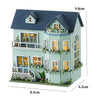 A miniature wooden dollhouse kit of a pink princess villa with decorative windows and LED lights.