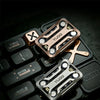 Close-up of a metal magnetic fidget slider in bronze and silver tones resting on a black keyboard surface.