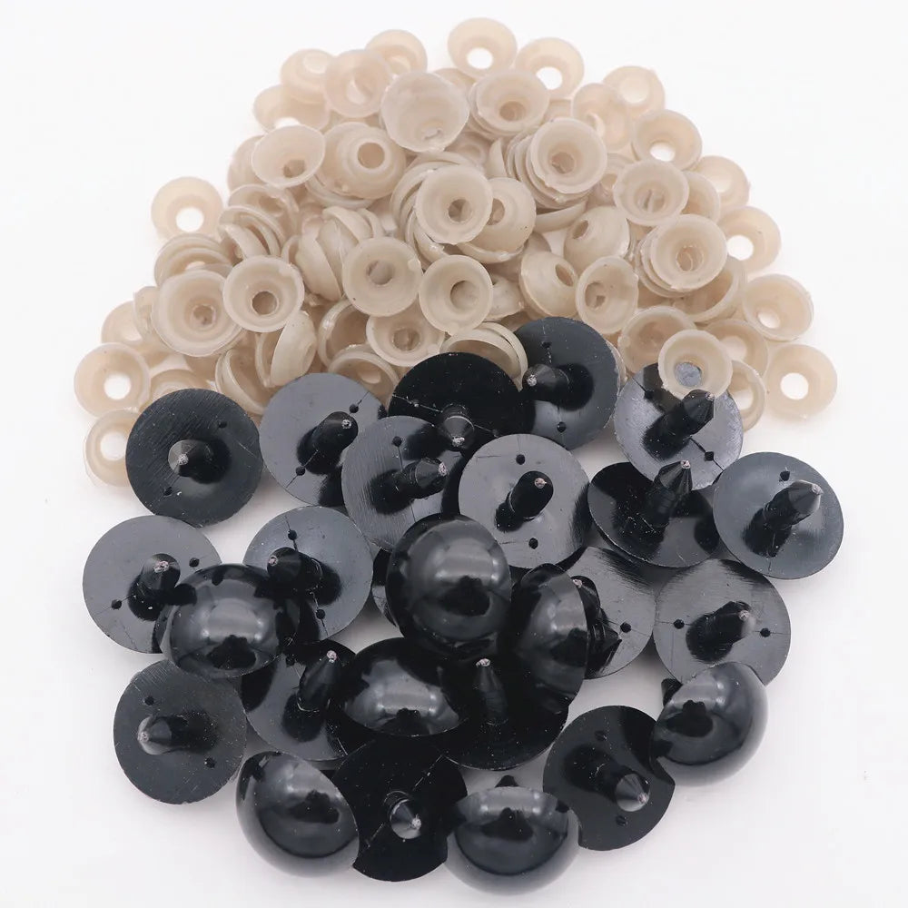 A collection of black plastic safety eyes with washers and light beige plastic eyes for crafting.