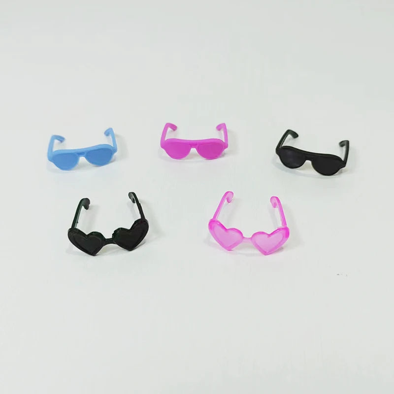 A collection of mini rubber duck accessories including sunglasses and hats in various colors like blue, pink, and black.