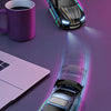 A blue 1:64 scale drift RC car model is shown in motion on a purple surface with a purple mug and a laptop nearby.