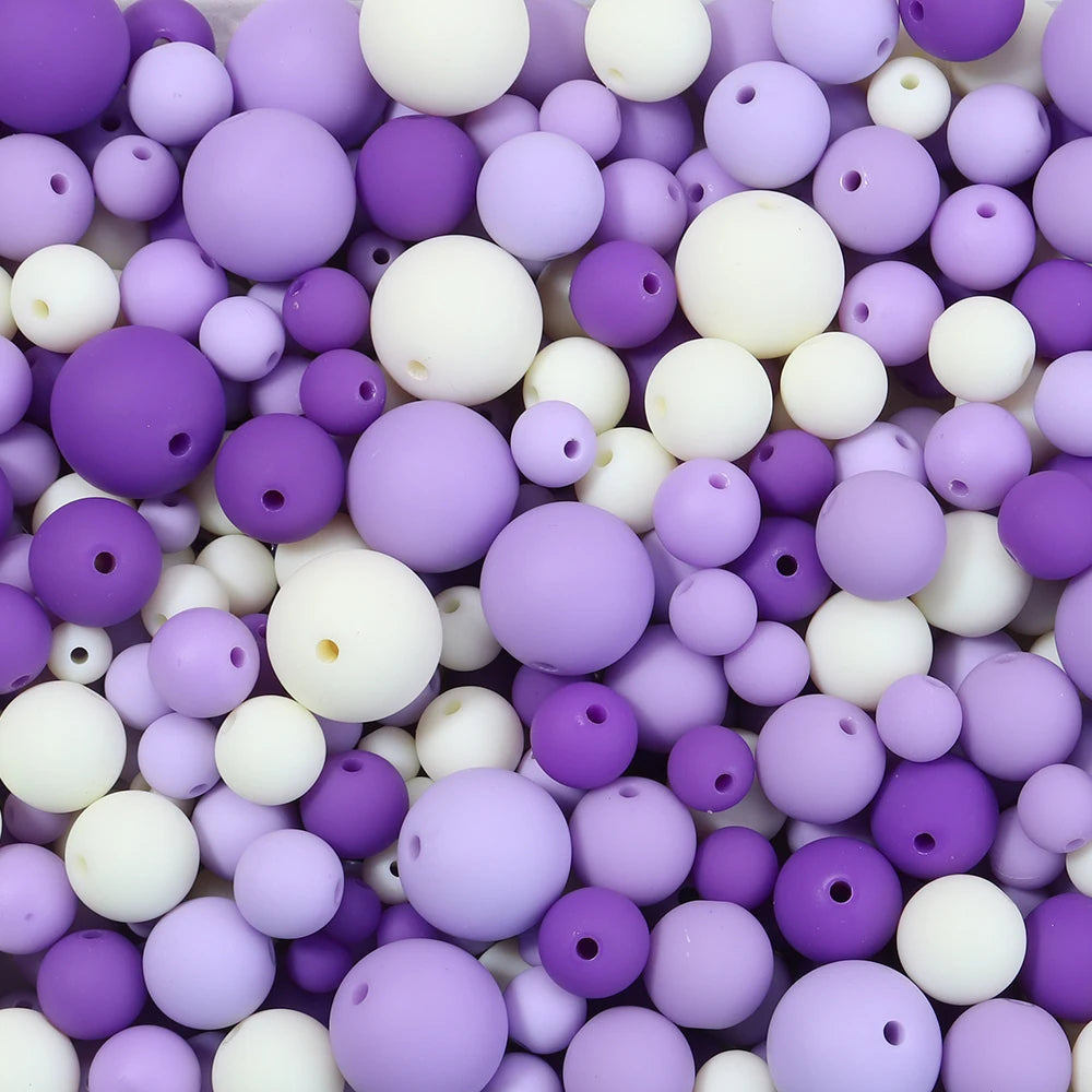 A close-up view of small, spherical matte acrylic beads in various shades of purple and white.