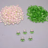 A collection of pink and green tulip flower glass beads, including loose beads and small packaged sets.