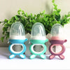 Three silicone baby food feeders with clear silicone domes and teethers in blue, green, and pink colors.