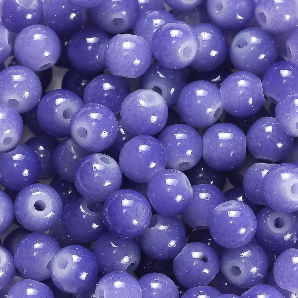 A close-up view of small, round glass beads in various shades of purple and blue.