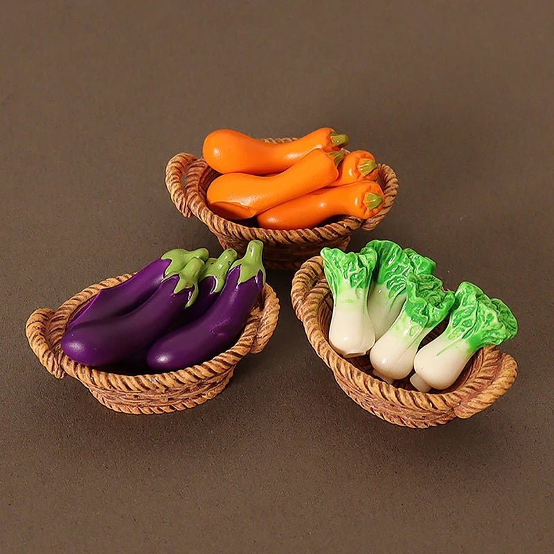 A miniature dollhouse vegetable basket play set showing orange carrots and green celery in woven baskets.