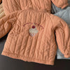 A peach-colored padded jacket for a child featuring embroidered text that reads You are my cup of cherry.