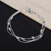 Elegant sterling silver snake chain bracelet for women displayed on a dark surface.