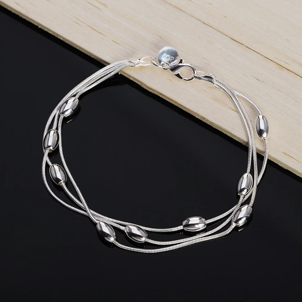 Elegant sterling silver snake chain bracelet for women displayed on a dark surface.