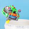 A green and gray gyroscopic unicycle fingertip spinner toy with large eyes is shown on a white surface.