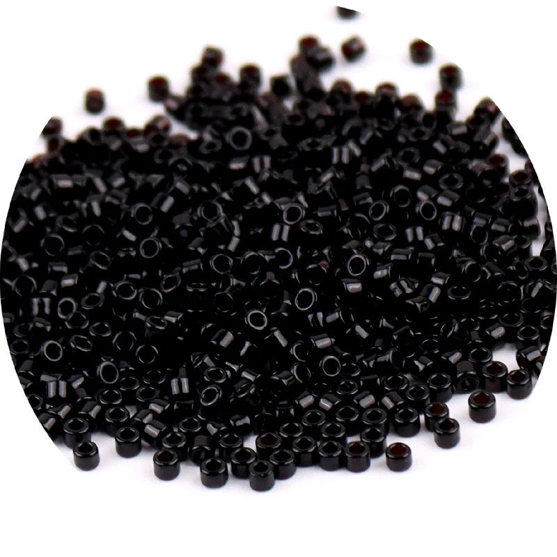 A pile of small, black metallic glass beads for jewelry making.