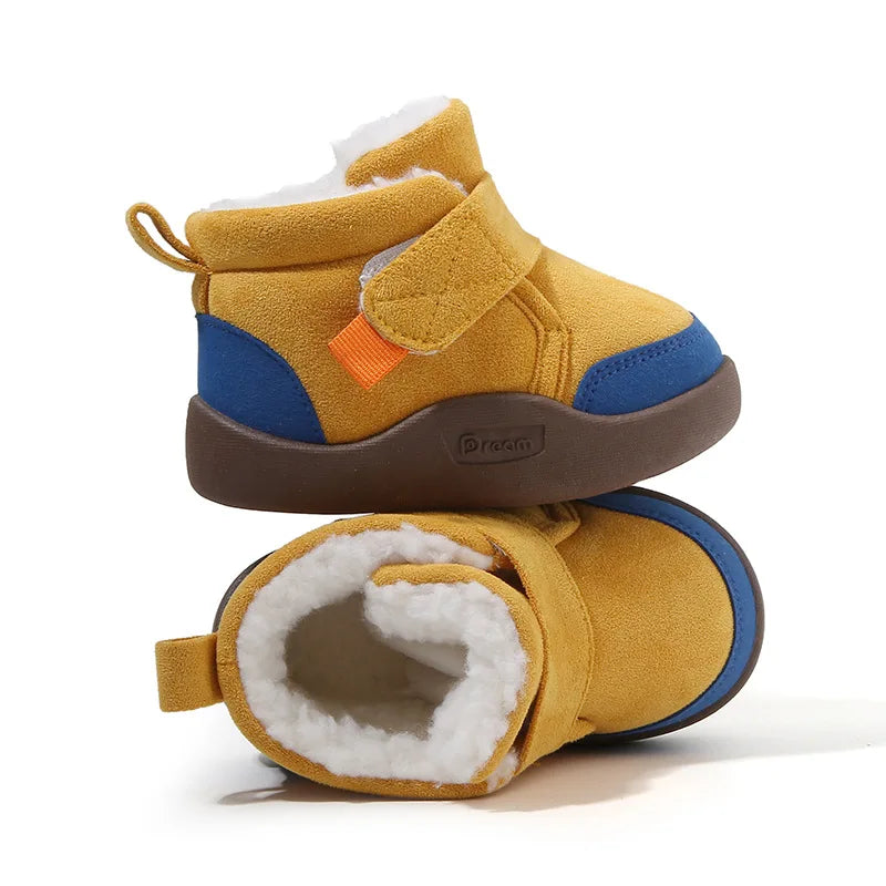 A pair of mustard yellow winter boots with blue accents and a fluffy white lining.