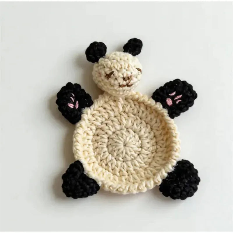 Handmade crochet animal coaster featuring a white body and black ears.
