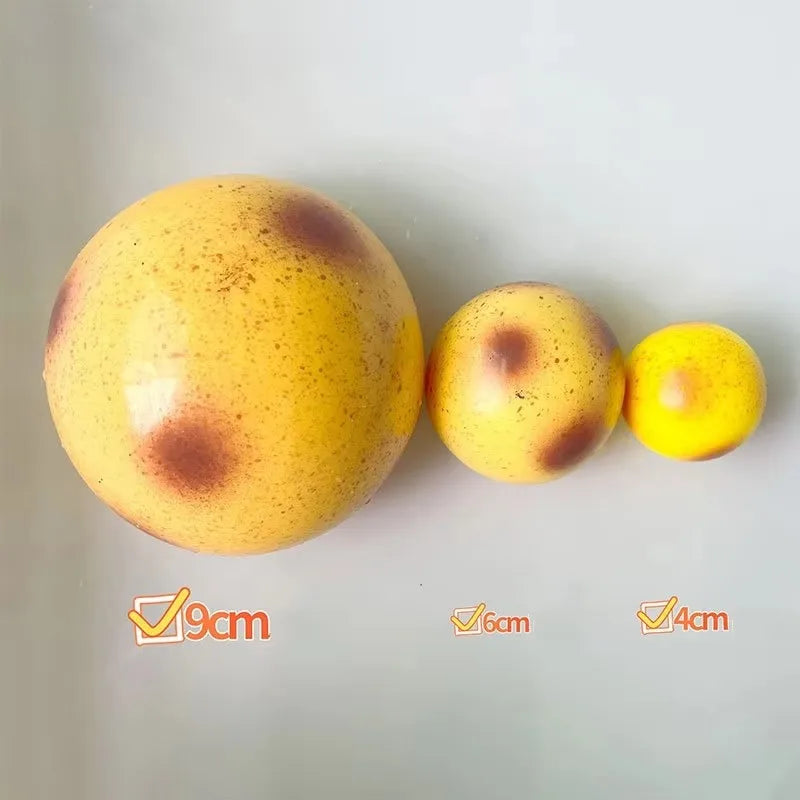 A yellow, spherical squishy potato fidget toy with brown spots, shown next to size markers.
