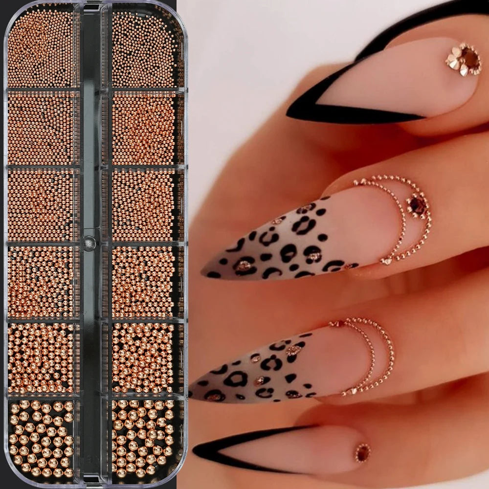 A close-up of gold caviar beads nail charms in mixed sizes being applied to a hand for DIY nail art.