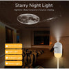 A white night light projecting a starry sky onto a bedroom ceiling, illuminating the room.