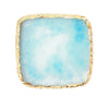A square resin nail art palette with a light blue, cloudy substance and a gold trim.