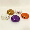 A set of three glitter stress relief balls shaped like a pumpkin, an eyeball, and a skull for Halloween