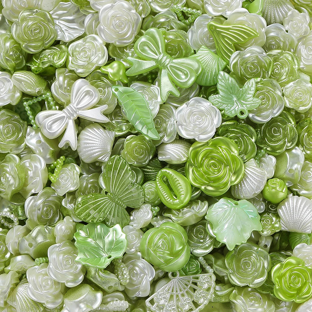A close-up of small, translucent green and white butterfly shell acrylic beads for DIY jewelry making.