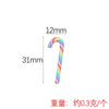 A colorful, striped polymer clay marshmallow charm is shown next to a measurement scale.
