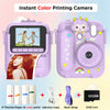 A pink instant color printing camera with a lens, paper, USB cable, and 32GB card visible.