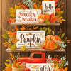 A display of wooden signs and pumpkins used as decorative elements for an autumn themed diamond painting kit.