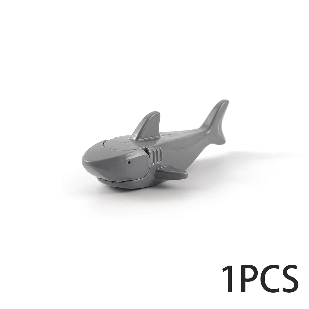 A gray plastic model of a shark or marine creature used as an ocean animal building block.
