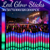 A display of various LED glow sticks in different colors and quantities, set against a concert or performance backdrop.