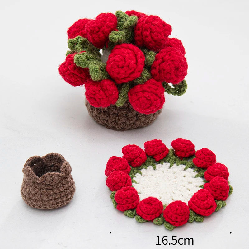 A hand-crocheted arrangement of red and green fabric flowers used as coasters or table mats.