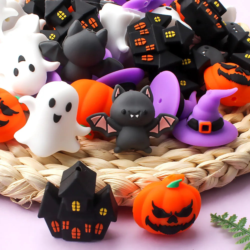 A collection of black and white silicone beads shaped like bats and pumpkins for jewelry making