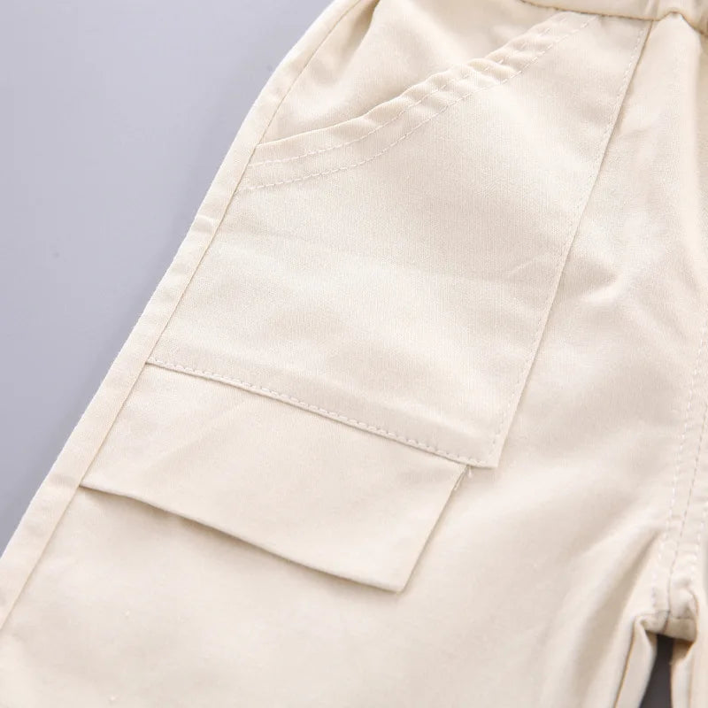 A close-up of a beige kids' summer outfit set featuring a top and shorts.