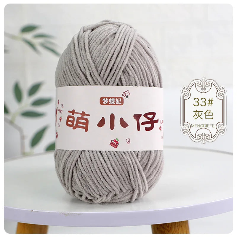 A ball of gray chenille yarn with a white label featuring Chinese characters for knitting and crochet