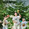 Three children playing outdoors with pull-string flying saucer toys.