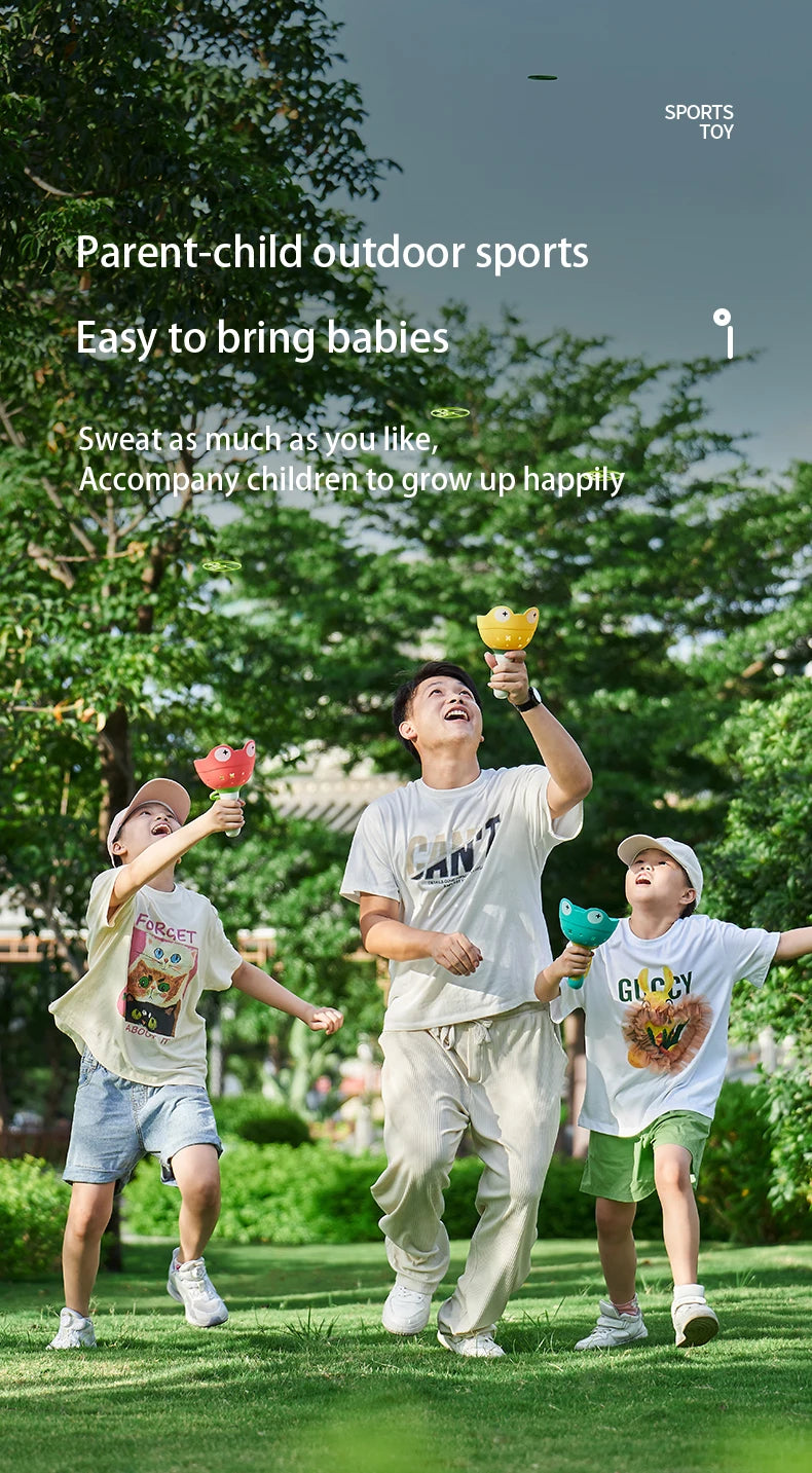 Three children playing outdoors with pull-string flying saucer toys.