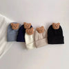 A collection of knitted baby hats in various shades of gray and navy blue, each featuring a small brown cartoon bear.