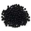 A pile of small, round, black imitation pearl beads for jewelry making.