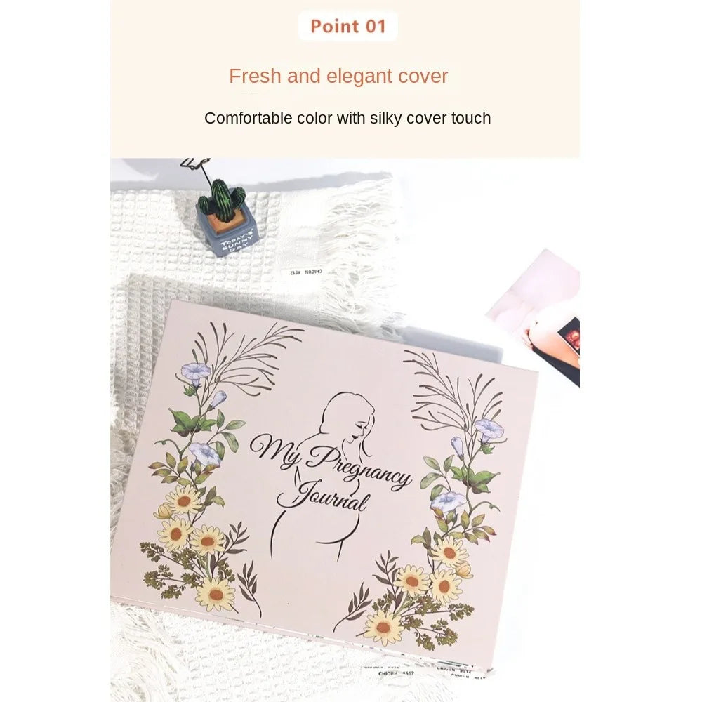 A pink pregnancy journal with floral designs is shown next to a green plant and tissue paper.