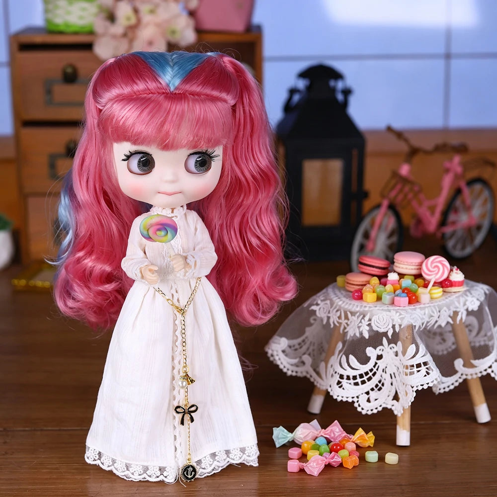 A pink and blue Blyth fashion doll with long hair standing on a wooden surface.