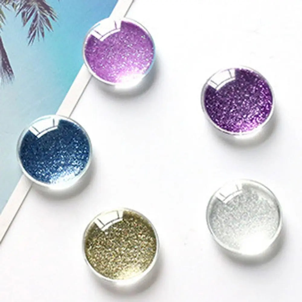 Assorted sizes of craft doll eyes with glitter finish in purple, blue, and silver shades