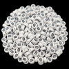 A pile of small white acrylic alphabet letter beads for jewelry making