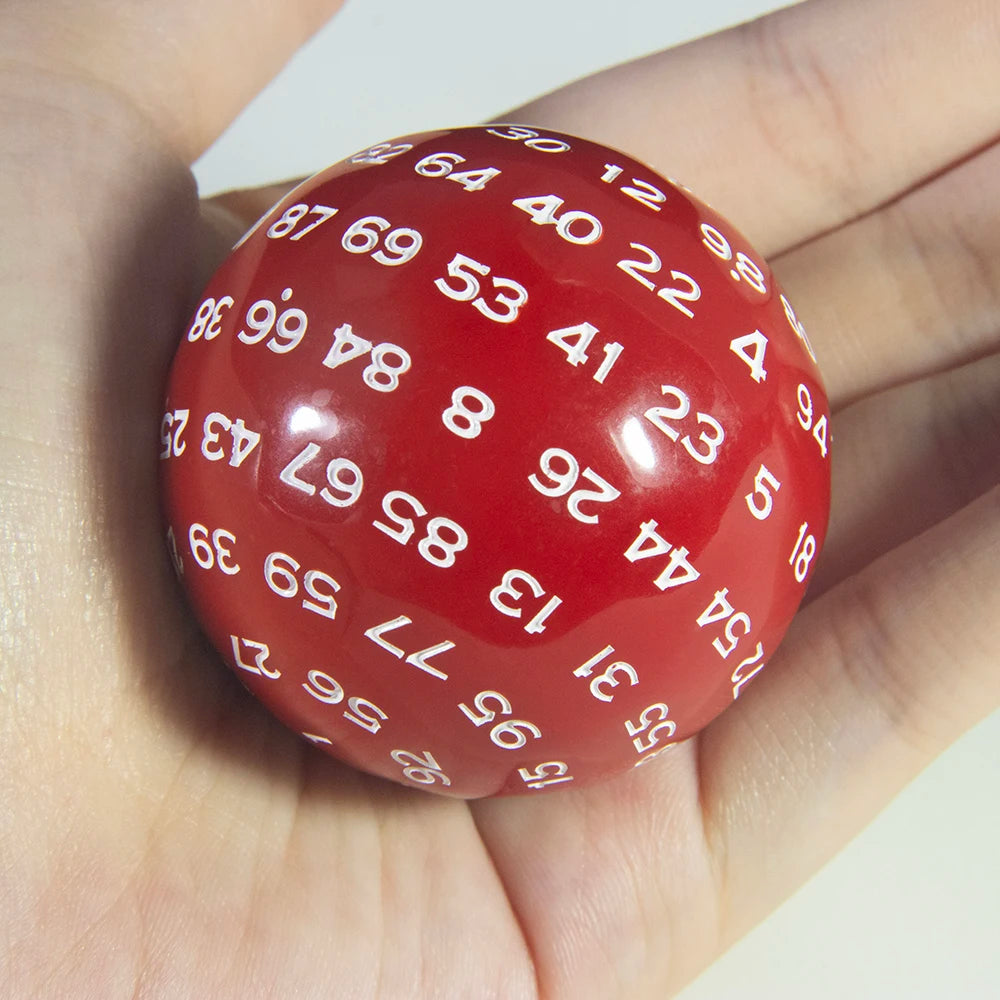 A hand holds a red 20-sided polyhedral die with numbers on its surface.