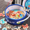 A blue wooden magnetic fishing game with various wooden fish shapes is displayed on a gray surface.