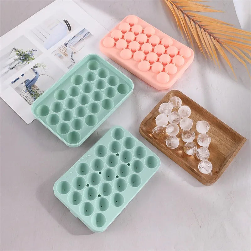 A collection of silicone grape cluster molds in pink and green are displayed on a white surface.
