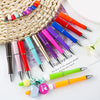 A collection of colorful beadable ballpoint pens with various tips and designs arranged on a white surface.