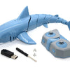 A blue shark toy model with a light and water spray attachment, along with its remote control and accessories.