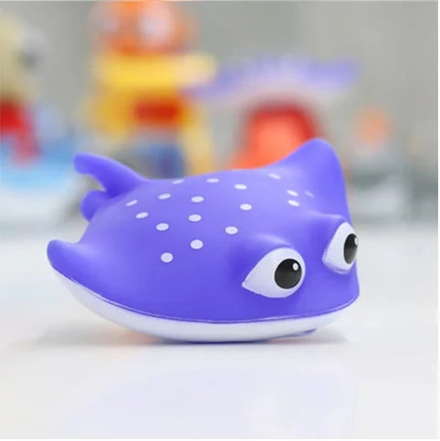 A purple rubber floating animal toy with large eyes and white spots, designed for baby bath time.