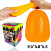 An orange squishy ball is being held by a hand, shown next to its packaging box.