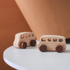 A wooden Montessori push cart toy set featuring a handcrafted beech car and bus with wooden wheels.