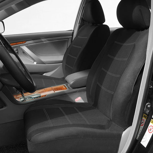 Interior view of a car showing black universal seat covers installed on the front seats.